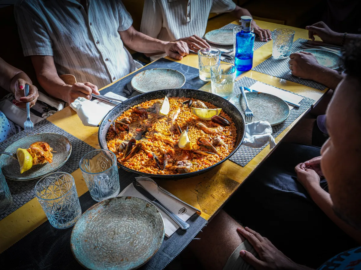 Grupo compartiendo una paella en una mesa de El Fogón de Saby