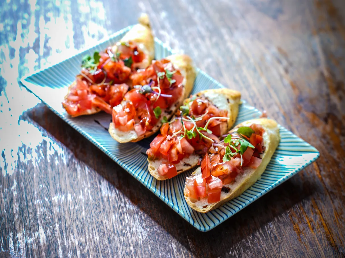 Bruschettas de tomate sobre pan tostado con albahaca